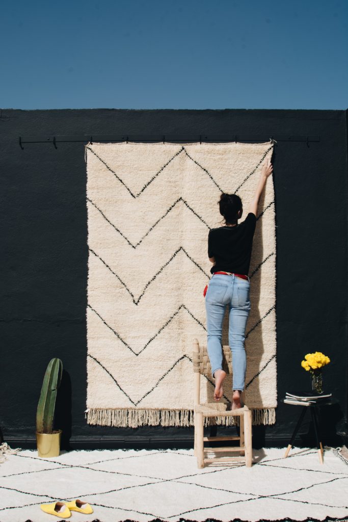 Tapis beni ouarain noir et blanc et femme berbere avec cactus